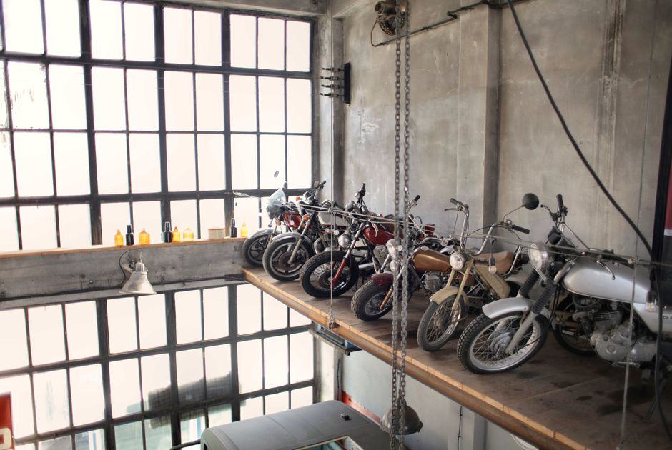 Motos anciennes remisées côte à côte sur une mezzanine d’atelier